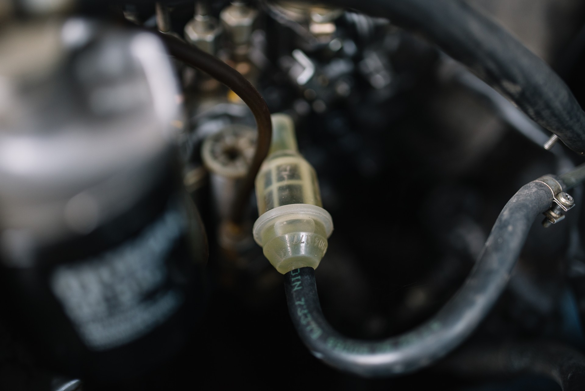 Stock photo: transparent inline fuel filter connected between fuel hoses in an engine compartment.