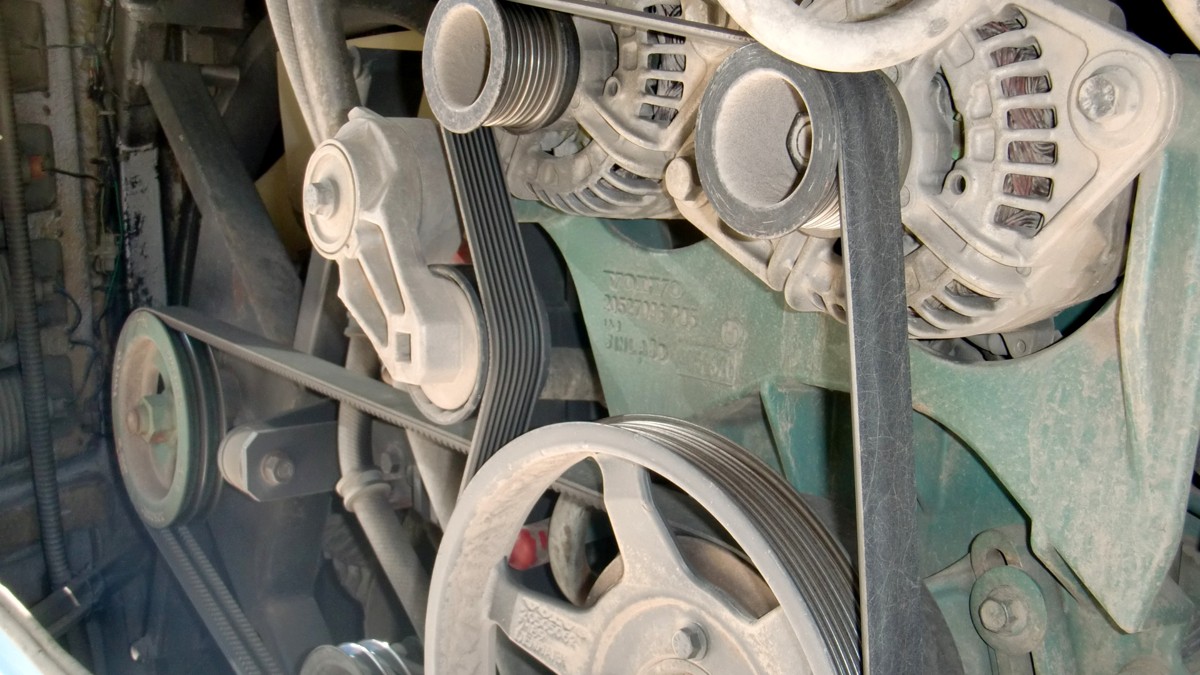 Stock photo: installed ribbed drive belts, pulleys, and coolant hoses on an engine.