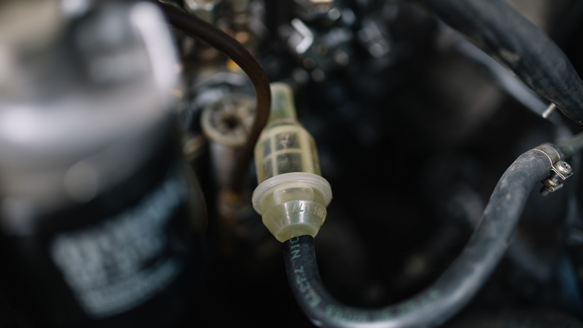 Stock photo: transparent inline fuel filter connected between fuel hoses in an engine compartment.