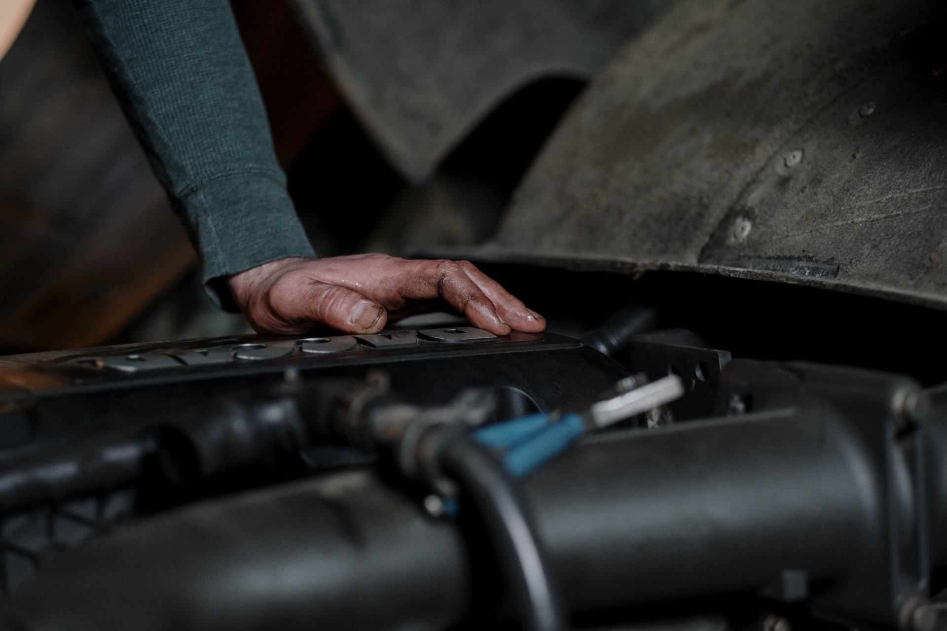 Stock photo: Close-up of a hand inspecting components beneath an open vehicle hood.