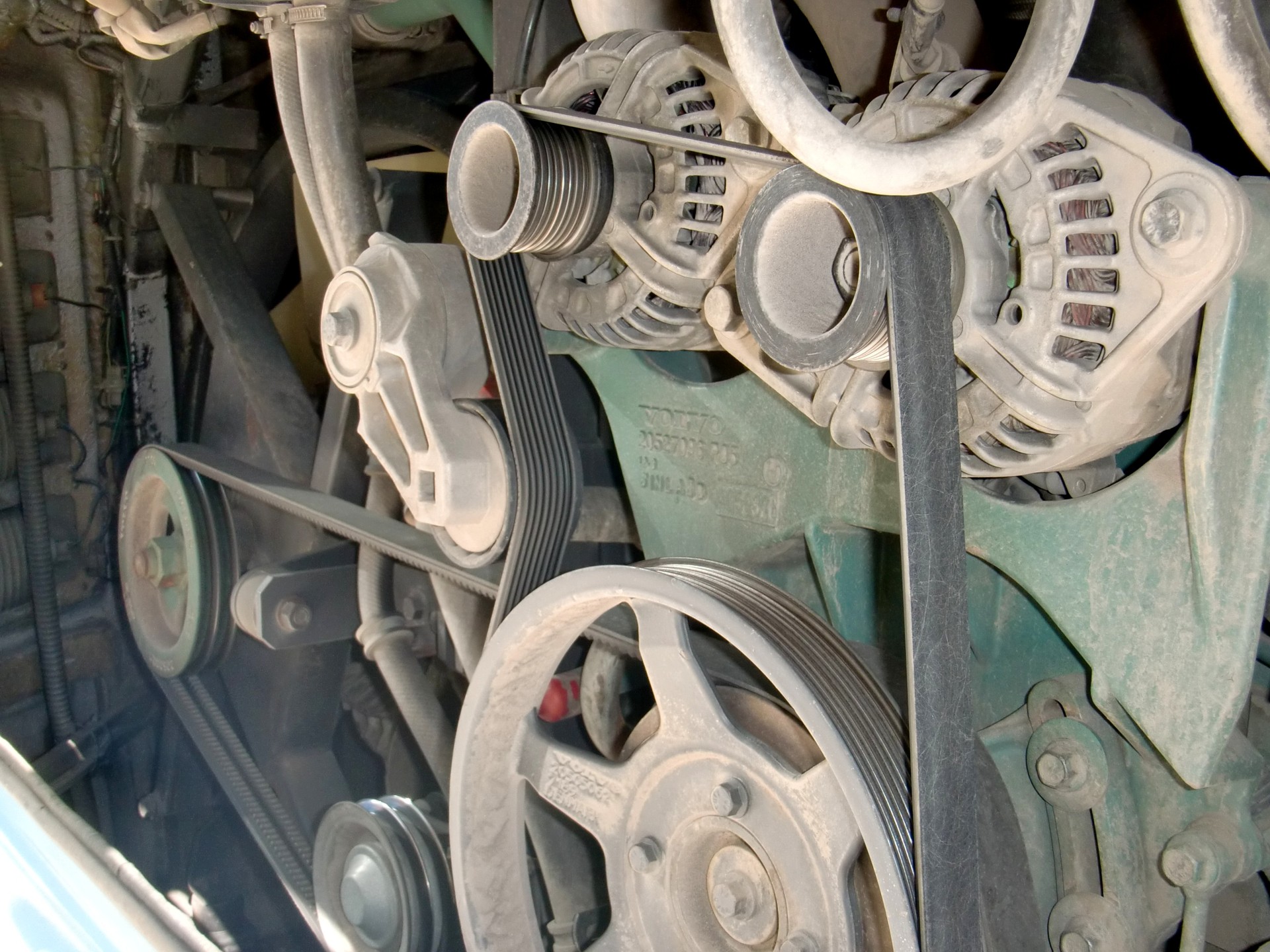 Stock photo: installed ribbed drive belts, pulleys, and coolant hoses on an engine.