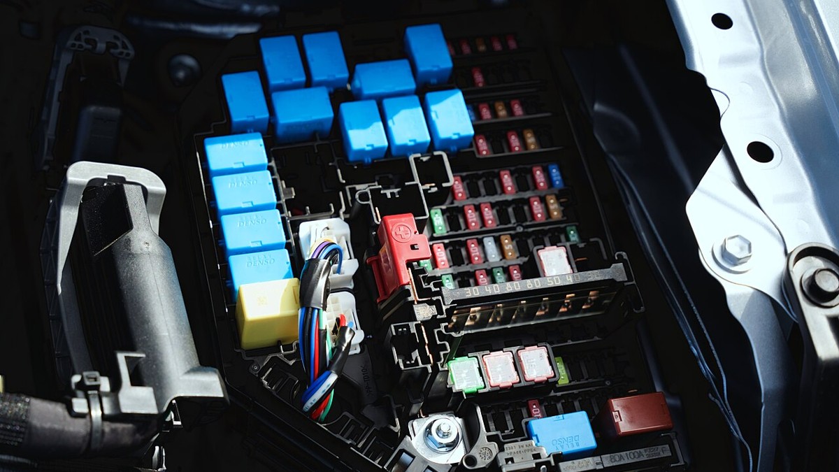 Stock photo: automotive fuses and blue electrical relays in an installed car fuse box.